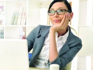 woman at desk looking up and smiling